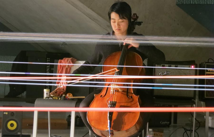 A cellist performs a piece with electronics